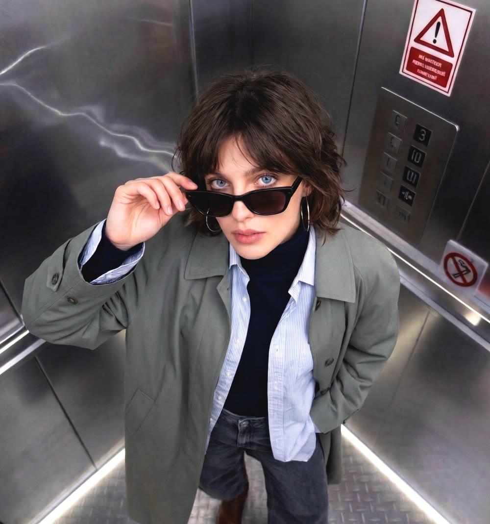 A woman posing in PhotoDA's Elevator room, shot from the ceiling camera inside a real steel elevator